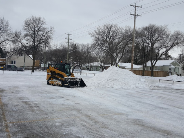 Skid Steer Plowing and Removing Snow From Parking Lot