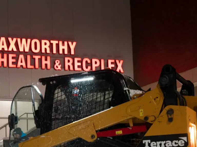 Skid steer clearing snow outside the Axworthy Health & RecPlex in Winnipeg